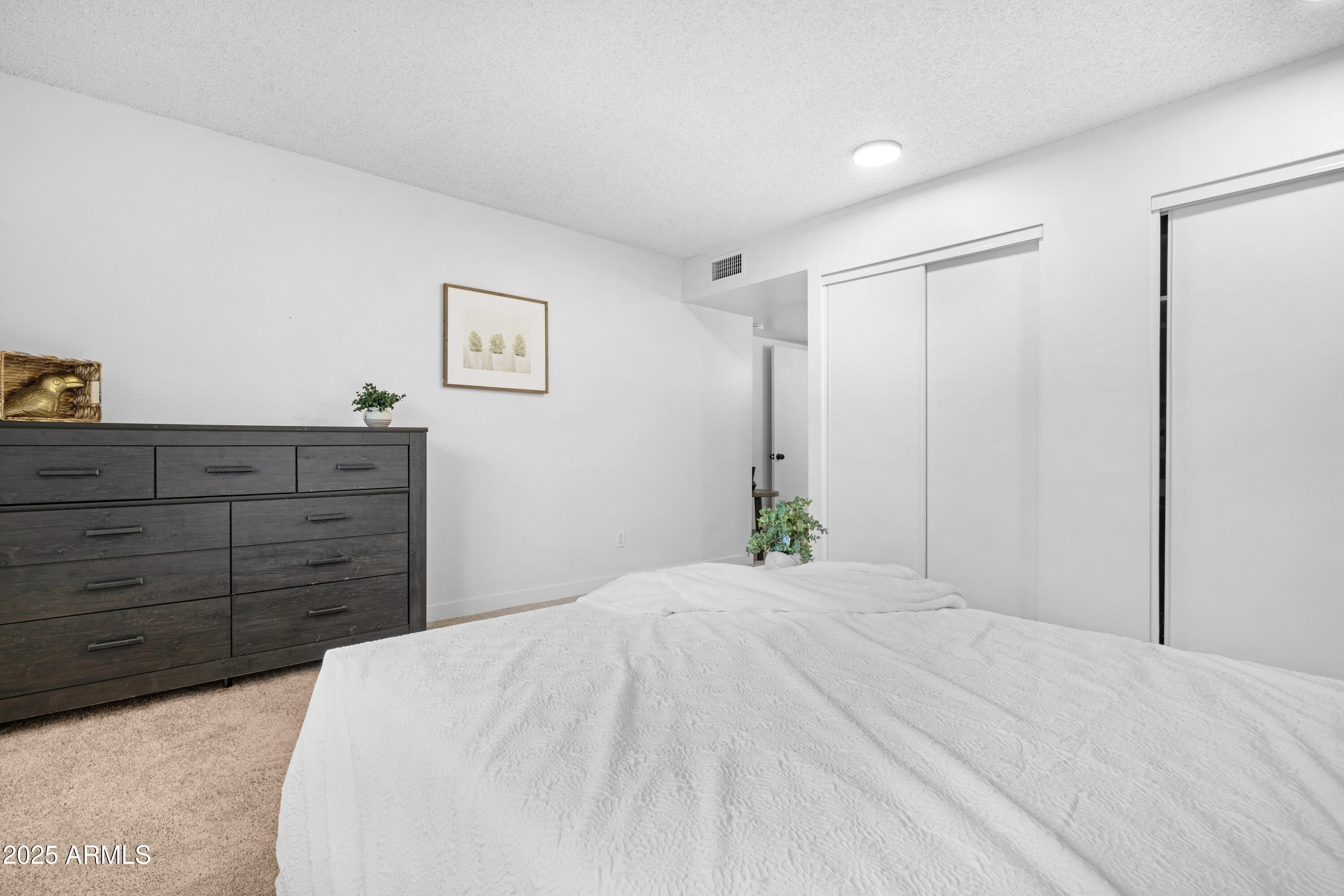 2042 West Elm Street Phoenix, AZ 85015 - Photo 23 of 35 a bed room with a bed mirror and a dresser