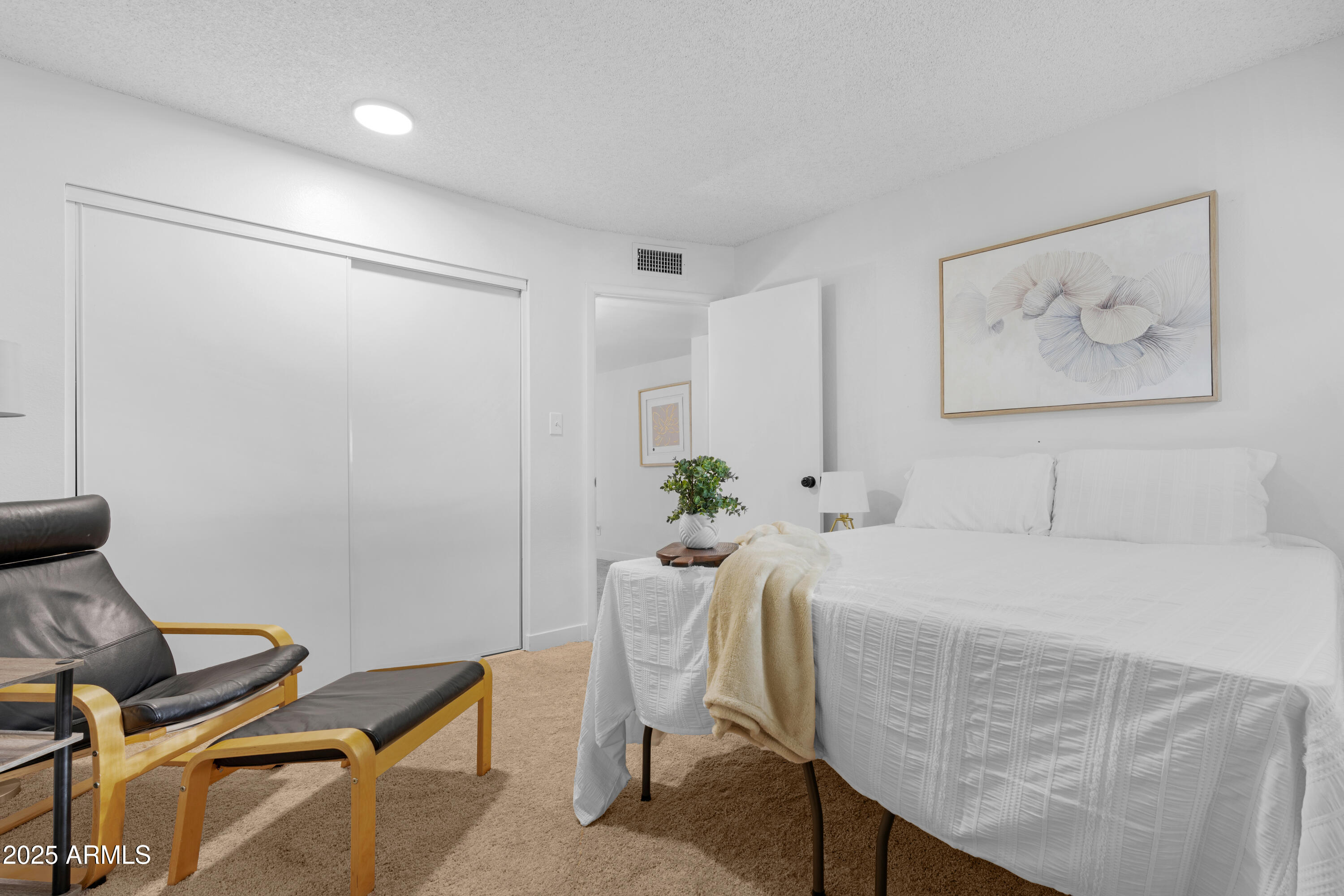 2042 West Elm Street Phoenix, AZ 85015 - Photo 27 of 35 a bedroom with a bed and a chair in it