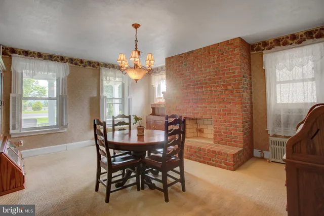a large kitchen with a fireplace and a chandelier