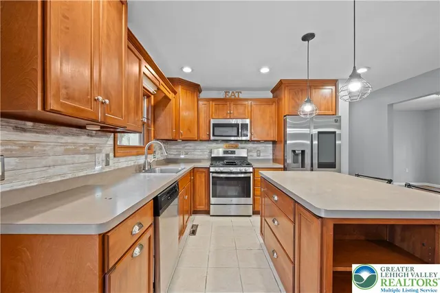 a kitchen with stainless steel appliances granite countertop a sink a stove and a refrigerator