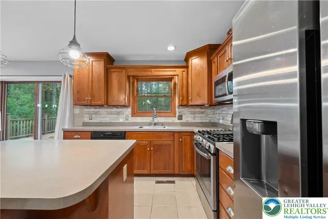 a kitchen with stainless steel appliances granite countertop a sink a stove and a refrigerator