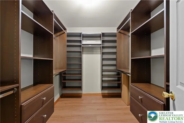 a view of walk in closet with clothes and shoes