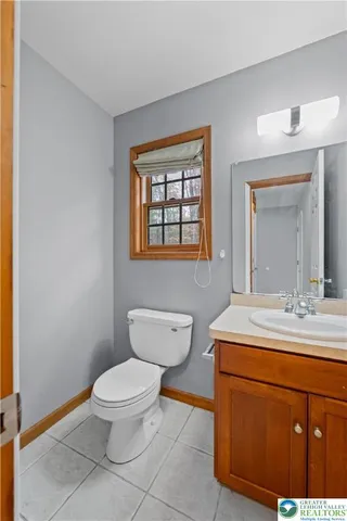 a bathroom with a toilet a sink and mirror