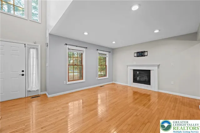 a view of an empty room with a window and fireplace