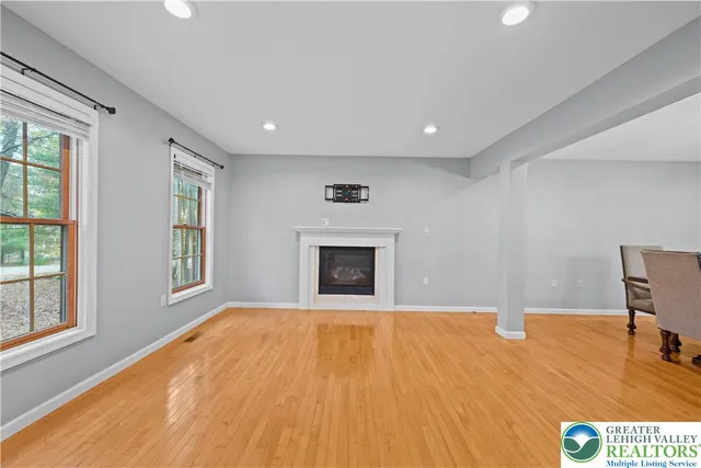 a view of an empty room with window and fire place