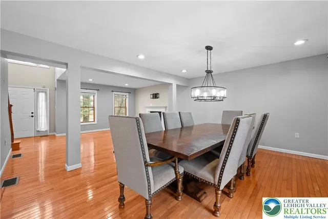 a dining room with furniture a chandelier and wooden floor
