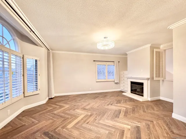 a view of empty room with fireplace and wooden floor