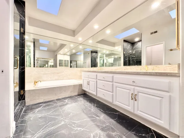 a large bathroom with a large tub and sink