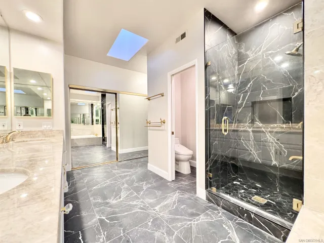 a bathroom with a glass shower door and a glass door