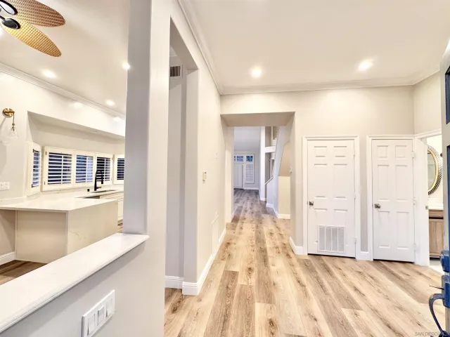 a hallway with a sink and a wooden floor