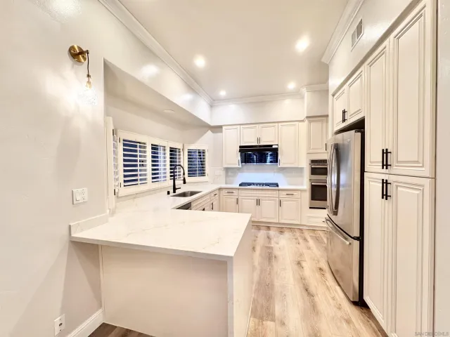 a kitchen with stainless steel appliances a refrigerator sink and microwave