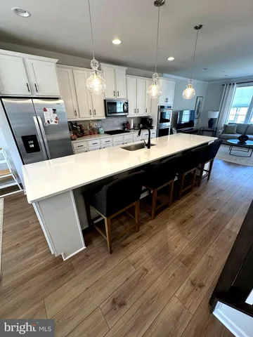 a large kitchen with lots of counter space a sink appliances and a center