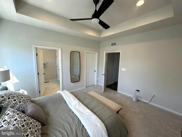 a bedroom with a large bed and a chandelier