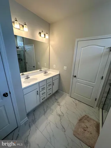 a bathroom with a double vanity sink and mirror