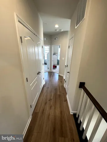 a view of a hallway with wooden floor and staircase