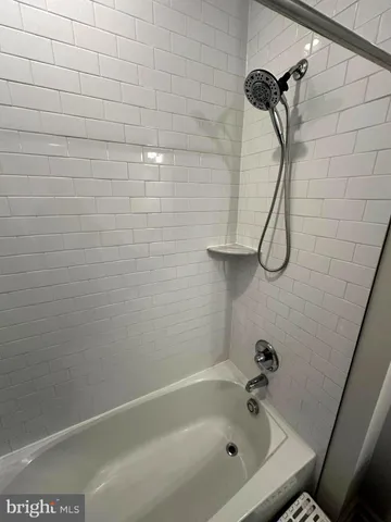 a bathroom with a bath tub with a shower