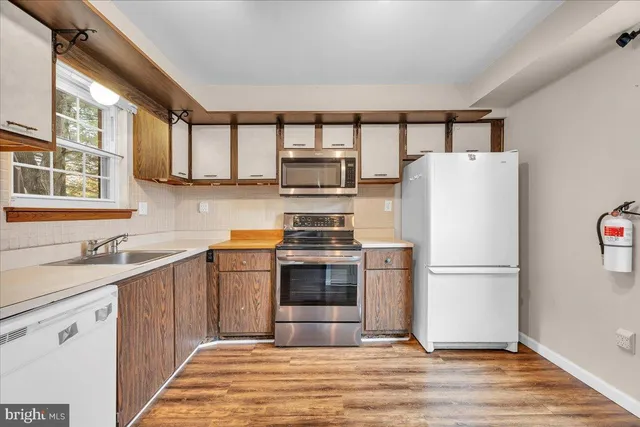 a kitchen with stainless steel appliances a refrigerator sink and cabinets