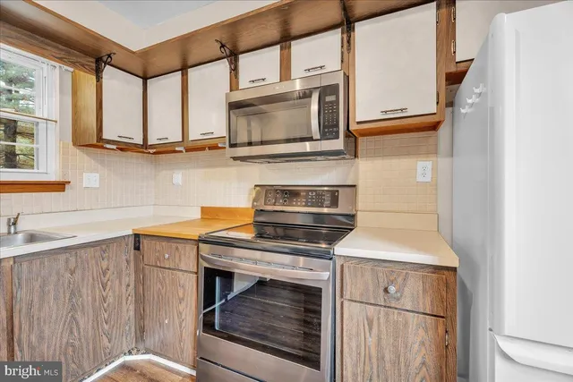 a kitchen with stainless steel appliances a stove microwave and sink