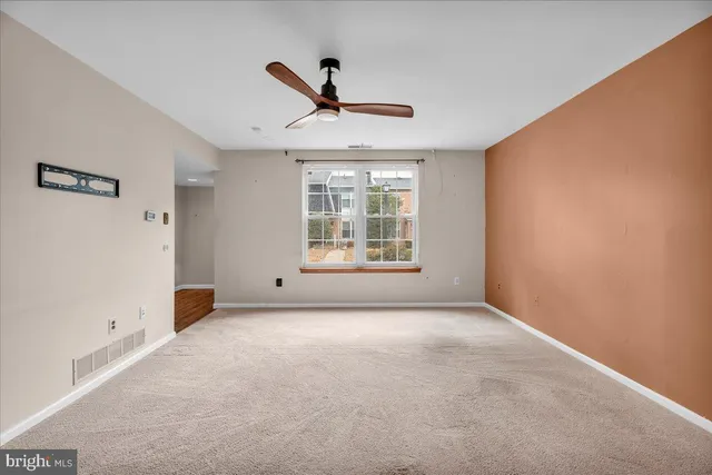 a view of a livingroom with a ceiling fan and window