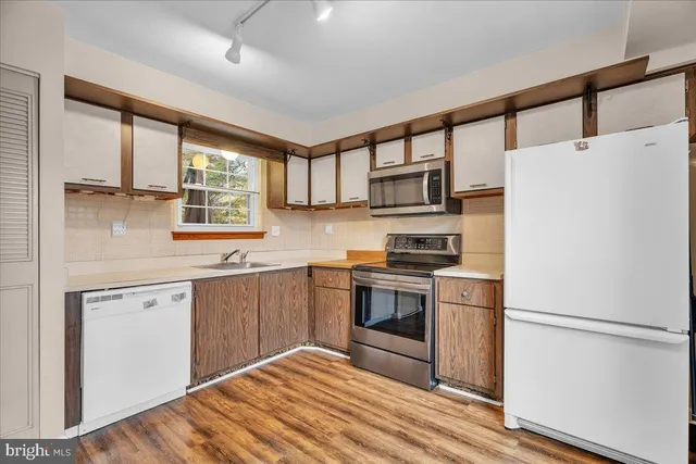 a kitchen with stainless steel appliances a stove a sink and a refrigerator