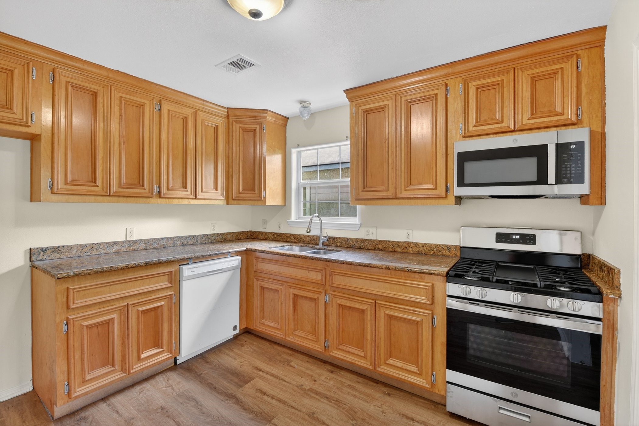 7013 St Augustine Street Houston, TX 77021 - Photo 12 of 35 a kitchen with cabinets stainless steel appliances and wooden floor