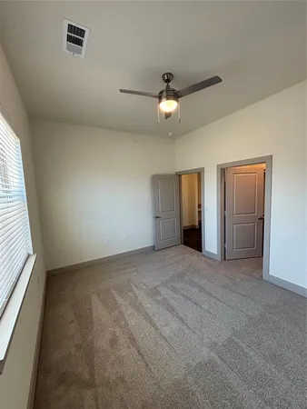 an empty room with a ceiling fan and a window