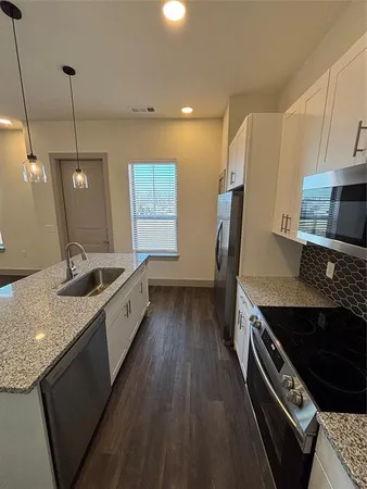 a large kitchen with a stove and a sink