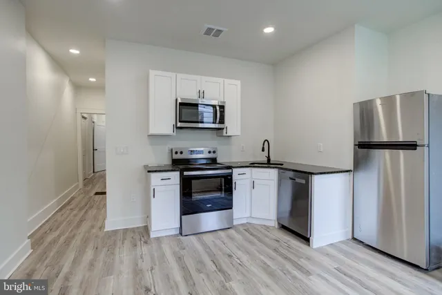 a kitchen with stainless steel appliances a refrigerator stove and microwave