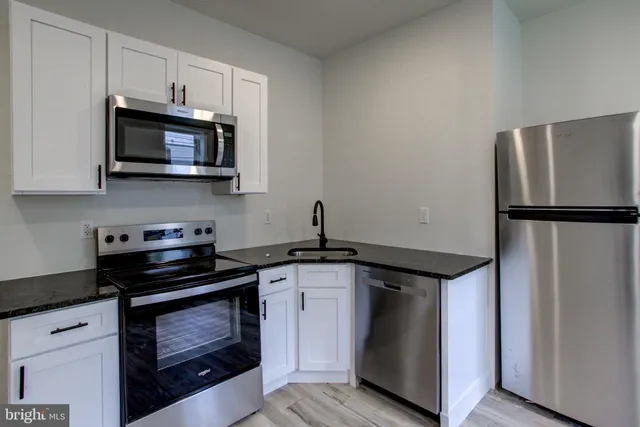 a kitchen with stainless steel appliances a stove a microwave and a sink