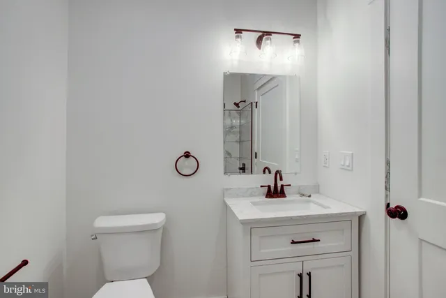 a bathroom with a sink a light fixture and a toilet