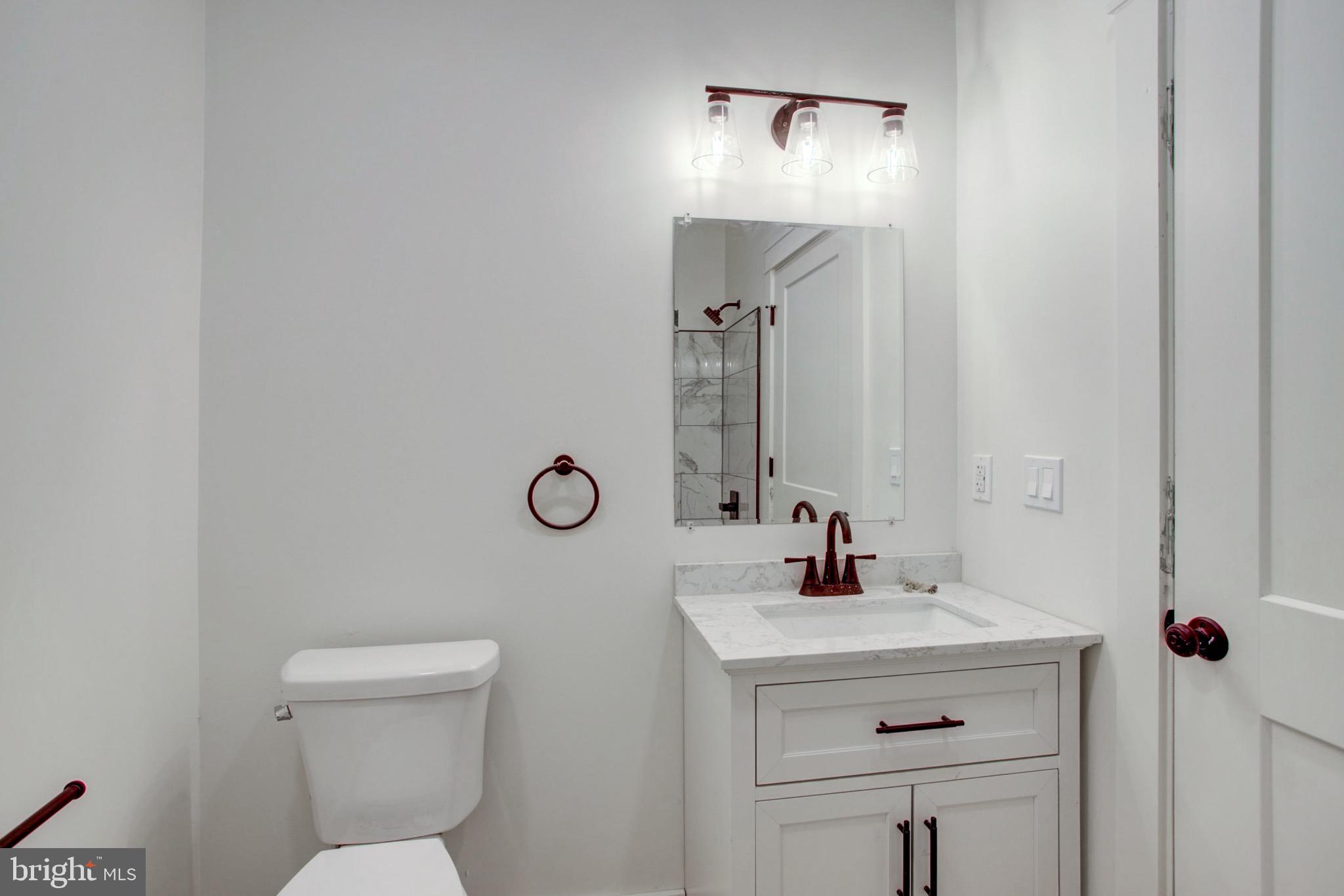 11 East Walnut Street Lancaster, PA 17602 - Photo 6 of 16 a bathroom with a sink a light fixture and a toilet