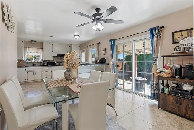 a living room with stainless steel appliances furniture a chandelier and a view of kitchen