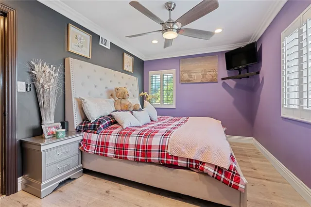 a bedroom with a bed chandelier and a window