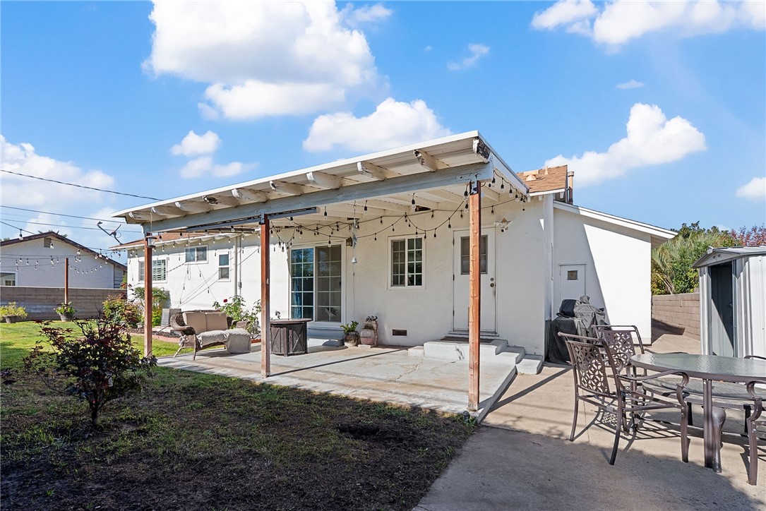 255 West Valencia Street Rialto, CA 92376 - Photo 22 of 34 a view of a patio with table and chairs potted plants and floor to ceiling window