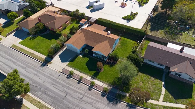 an aerial view of a house with a yard and tennis court
