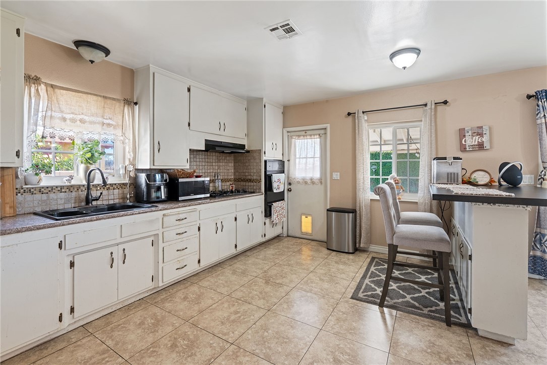 255 West Valencia Street Rialto, CA 92376 - Photo 9 of 34 a kitchen with stainless steel appliances kitchen island granite countertop a sink and cabinets