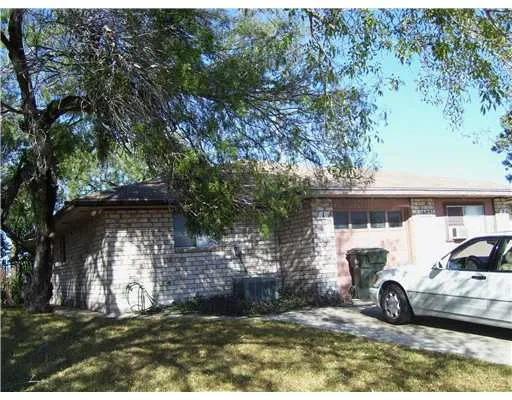 a view of a wooden house with large trees