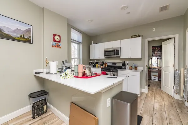 a kitchen with a sink cabinets and wooden floor