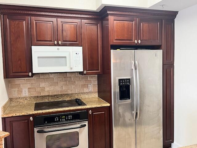 3 Renaissance Way, Unit 411 Boynton Beach, FL 33426 - Photo 2 of 9 a kitchen with a refrigerator stove and cabinets