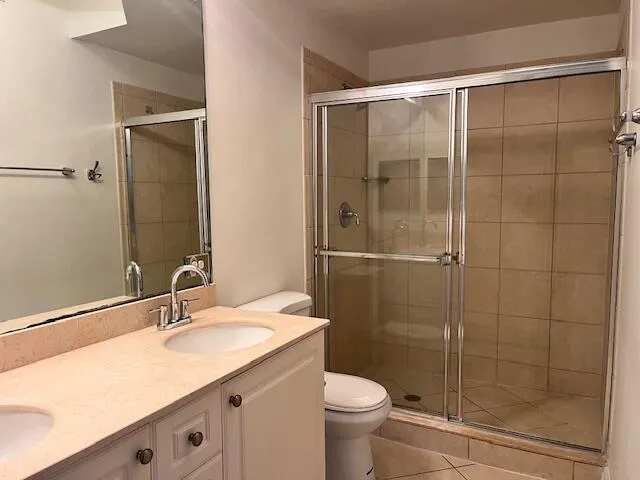 a bathroom with a shower sink vanity and toilet