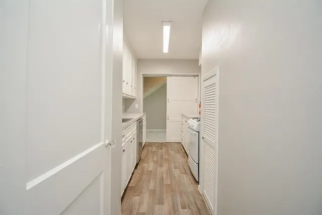 a view of a hallway with wooden floor and staircase
