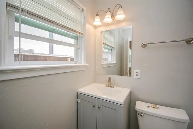 a bathroom with a sink a toilet and a mirror