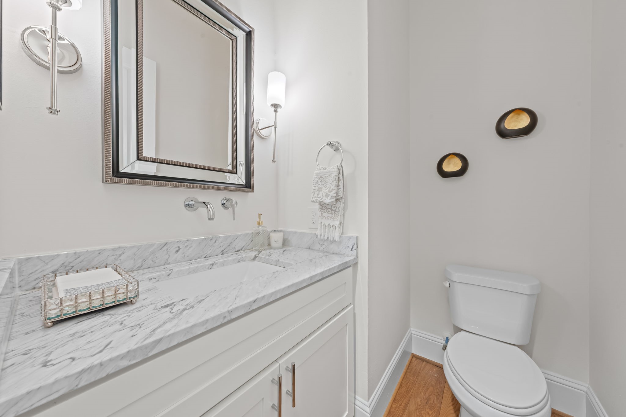 110 East 26th Street, Unit B Houston, TX 77008 - Photo 16 of 43 This sizable powder room offers a sophisticated retreat for guests, featuring gorgeous counters and custom fixtures. The design emphasizes timeless elegance and quality, ensuring that even the home's most functional spaces feel curated and high-end.