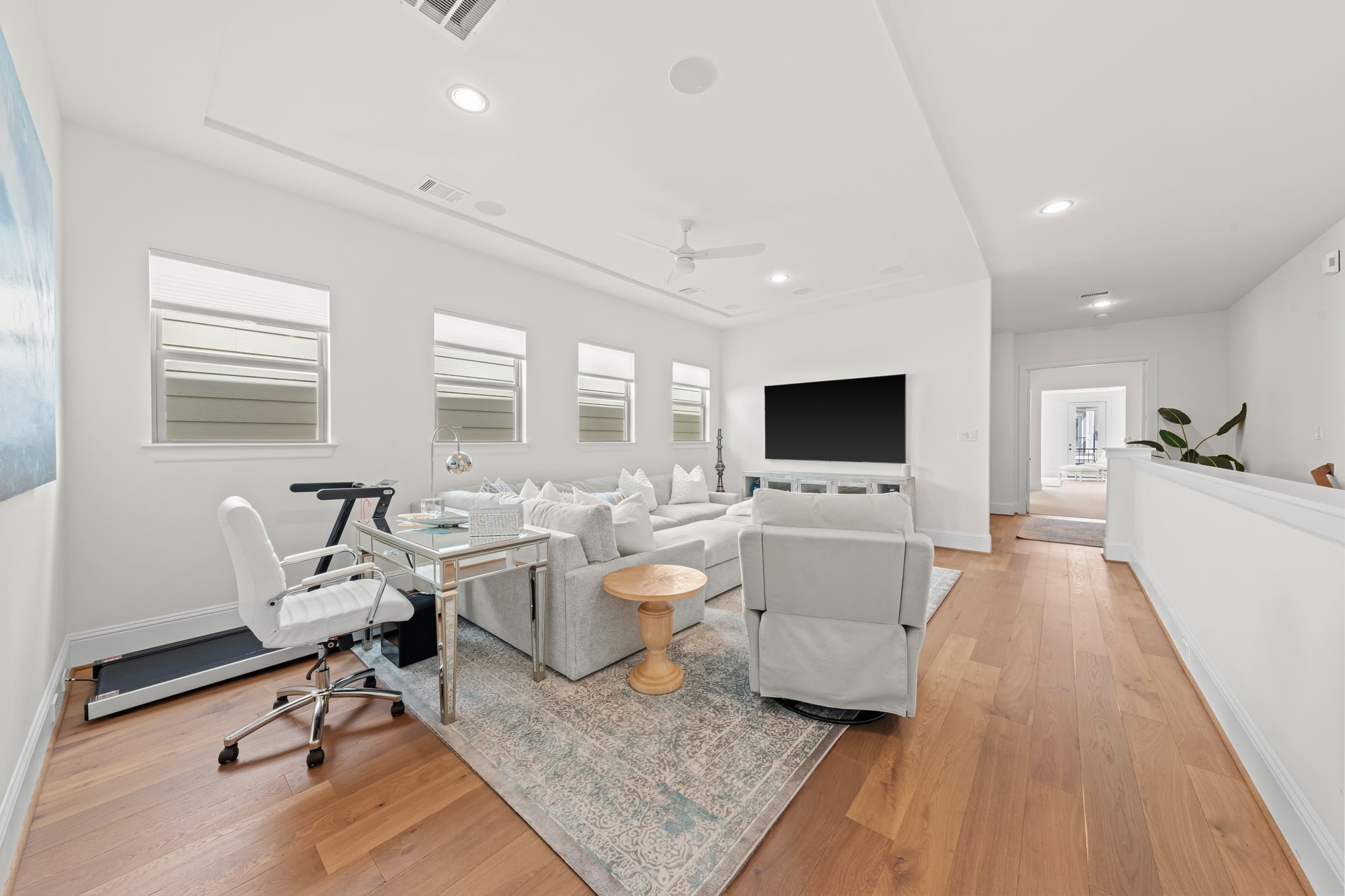 110 East 26th Street, Unit B Houston, TX 77008 - Photo 21 of 43 This alternate view highlights the true scale of the bonus room, with ample space to incorporate a home office or exercise zone alongside a media area. Note the hallway design, which creates an intentional sense of privacy and seclusion for the entrance to the Primary Retreat on the north side of the home.