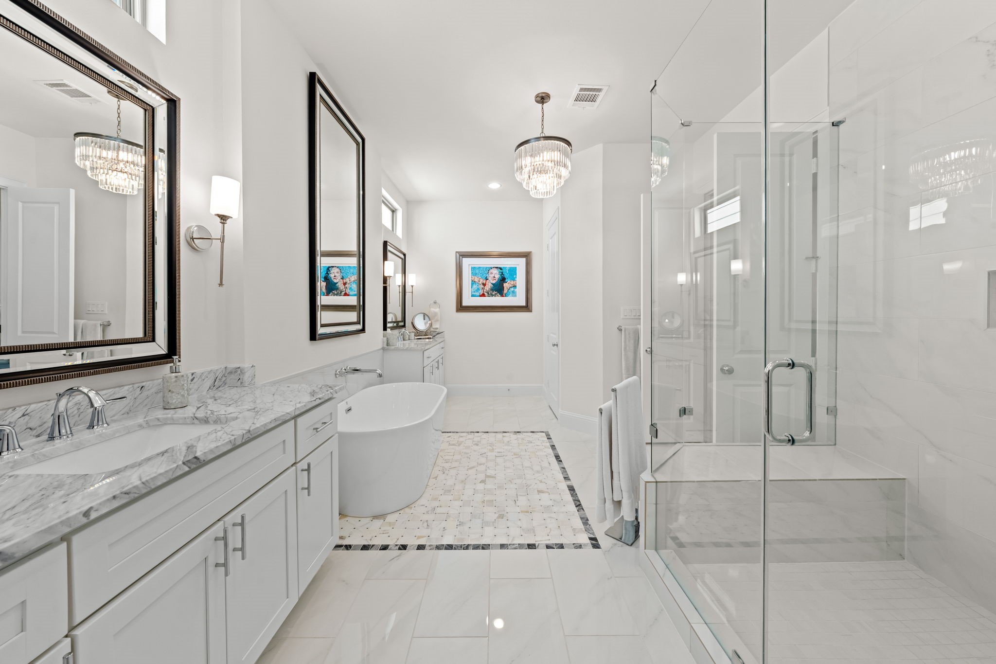 110 East 26th Street, Unit B Houston, TX 77008 - Photo 27 of 43 This additional view showcases the bath's impressive scale and high-end finishes, from the beautiful marble to the oversized shower equipped with a built-in bench. A refined chandelier centers the room, while a separate commode area, ample cabinetry, and expansive counter space ensure the suite is as functional as it is stunning.