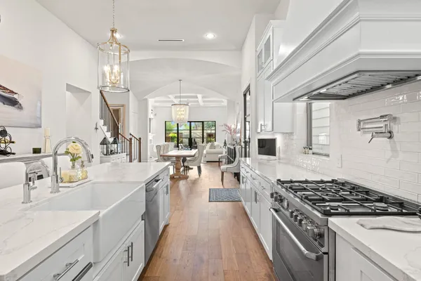 a large kitchen with kitchen island a large counter space a sink stainless steel appliances and cabinets
