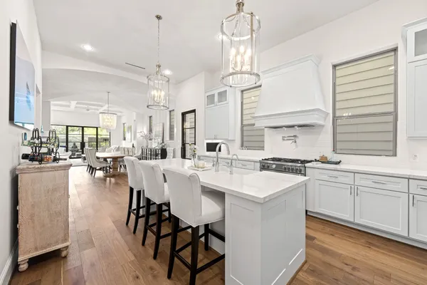 a large kitchen with cabinets a sink dining table and chairs