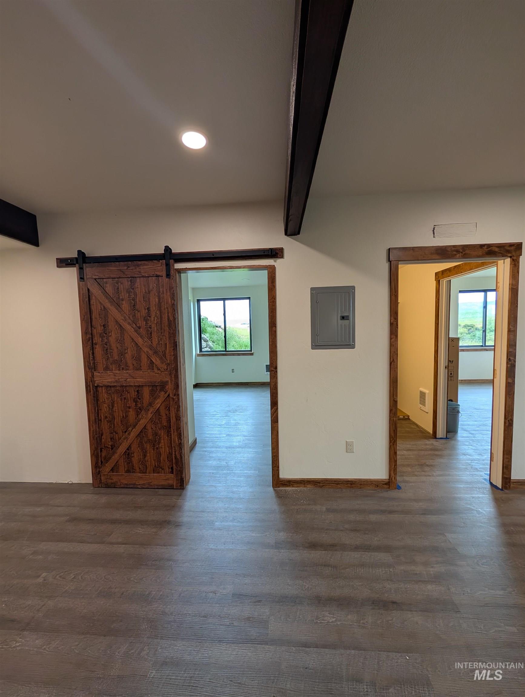 137 Angus Ranch Grangeville, ID 83530 - Photo 22 of 49 Empty room featuring beamed ceiling, wood finished floors, a barn door, electric panel, and recessed lighting
