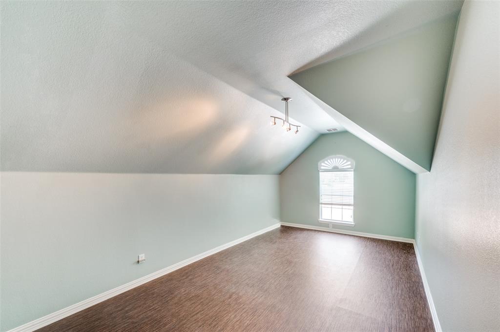 3912 Sovereign Drive Bedford, TX 76021 - Photo 24 of 34 Bonus room with a textured ceiling, dark wood-type flooring, and vaulted ceiling