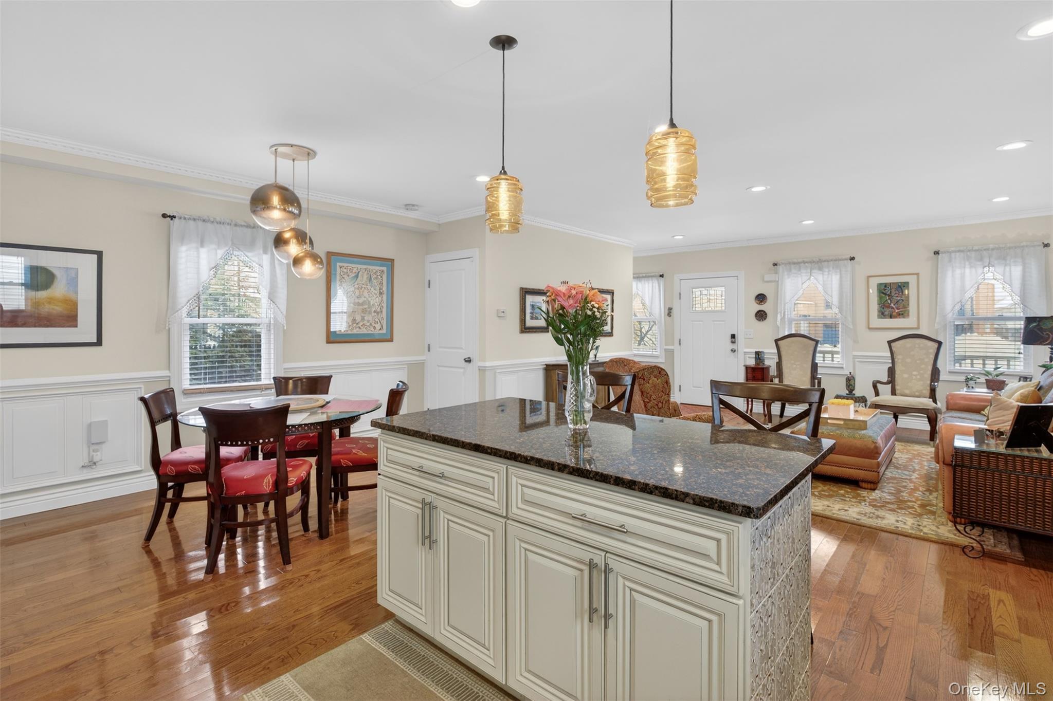 35 Kent Street Beacon, NY 12508 - Photo 14 of 42 a view of a dining room and livingroom with furniture wooden floor a rug a flat screen tv a rug a fireplace and a chandelier